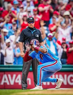 a baseball player catching a ball while standing next to another player on top of a field