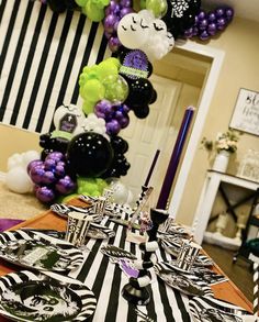 the table is set with black, white and purple decorations