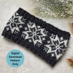 a black and white knitted wrist warmer with snowflakes on it next to an evergreen branch