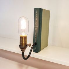 a lamp that is next to a book on a shelf