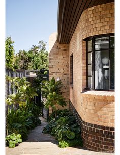 an outside view of a brick building with plants and trees