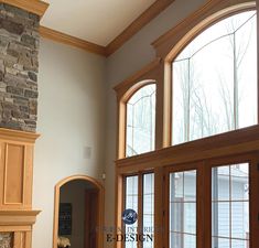 a living room filled with furniture and large windows next to a stone fireplace mantel