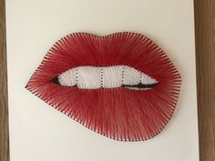 a piece of art that looks like a woman's mouth with red lipstick on it