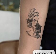 a woman's arm with a tattoo on it that has snakes crawling around her head