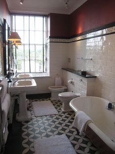 a bathroom with black and white tile flooring next to a bathtub, toilet and sink