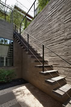 a set of stairs leading up to a building with stone walls and metal railings