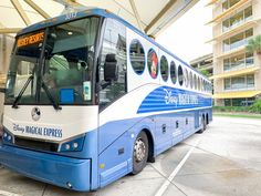 a blue and white bus parked in front of a building