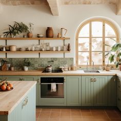 a kitchen with green cabinets and wooden counters