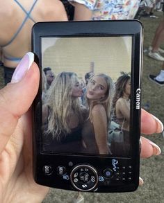 a person holding up a cell phone to take a photo with their friends in the background