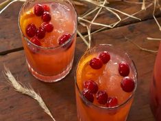 two glasses filled with orange juice and cranberries