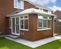 a brick house with white trim and windows