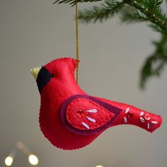 a red bird ornament hanging from a christmas tree