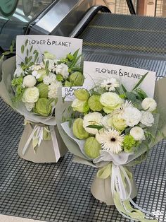 two bouquets of flowers sitting on top of an escalator next to each other