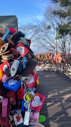 a bunch of love locks are attached to a pole in front of a large group of people