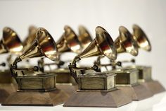 several brass colored musical instruments sitting on top of each other in front of a white wall