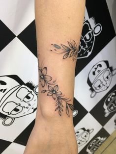 a woman's foot with flowers and leaves on the bottom part of her leg