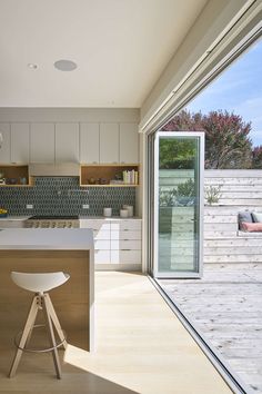 an open kitchen and dining area with sliding glass doors leading to the outside decking