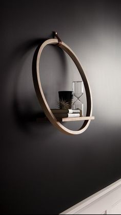 a wall mounted shelf with a vase and some books on it in a dark room