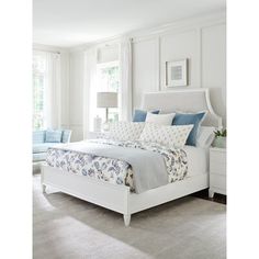 a bedroom with white furniture and blue accents