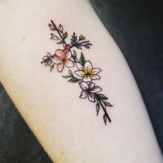 a small tattoo with flowers on the side of the arm and behind it is an arrow