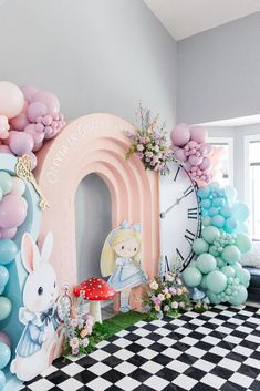 a room decorated in pastel colors with balloons and an arch shaped like a clock