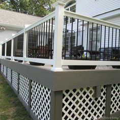 a deck with trellis on the side of it in front of a house