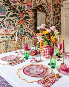 the table is set with colorful dishes and place settings