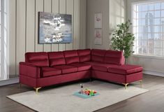 a living room with a red sectional couch and coffee table in front of the window