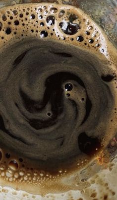 the liquid in the bowl is brown and black, with bubbles on it's surface