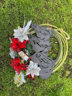 a wreath laying on the ground next to a hose