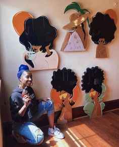 a woman sitting on the floor in front of some paper cutouts with different hair styles