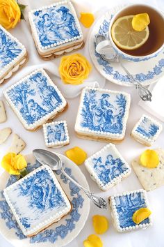 blue and white desserts with lemon slices on the side next to a cup of tea