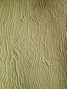 a close up view of a quilted material with wavy lines and curves on it