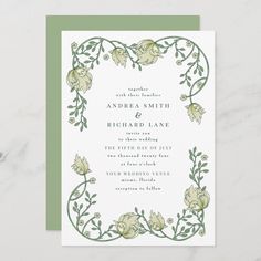 an elegant wedding card with green and white flowers on the front, surrounded by greenery