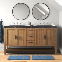 a bathroom with two sinks and mirrors on the wall next to a blue rug in front of it