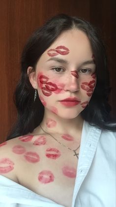 a woman with red lipstick painted on her face and chest, posing for the camera