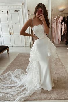 a woman taking a selfie in her wedding dress while looking at her cell phone