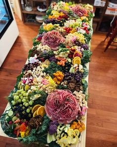 a long table filled with lots of different types of vegetables and fruits on top of it