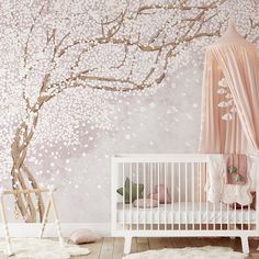 a baby's room decorated in pink and white with a cherry blossom tree mural