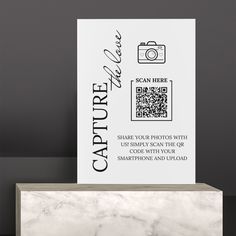 a white card with black text on it next to a marble block that reads capture your photo