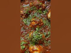 meatballs covered in sauce and parsley on top of a pan filled with vegetables