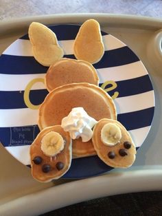 a plate topped with pancakes covered in chocolate chips and banana slices on top of it