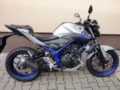 a blue and silver motorcycle is parked on the sidewalk