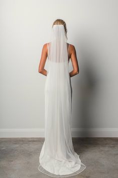 the back of a bride's wedding dress, with her veil draped over her head