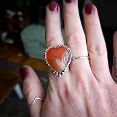 This funky carnelian heart is set in .925 sterling silver with hand forged sterling accents and will be finished in buyers size. The ring comes on a split sterling silver band. Please know your size and email or make note at checkout! All jewelry is handmade by Bree in Philadelphia, PA. Packaged with recycled products, all ready to ship items are processed in 3-5 days. Please allow a 10 day production period for all made to order pieces. Handmade Heart-shaped Sterling Silver Ring, Handmade Sterling Silver Heart Cut Ring, Unique Handmade Heart Ring For Valentine's Day, Bohemian Heart-shaped Rings For Gifts, Unique Heart-shaped Stamped 925 Rings, Unique Heart Ring For Valentine's Day, Handmade Bohemian Heart-shaped Rings, Unique Sterling Silver Heart Ring, Heart Shaped Carnelian Gemstone Jewelry