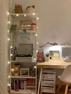 a room with a desk, chair and bookshelf filled with various items on it