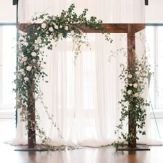 the wedding arch is decorated with white flowers and greenery for an elegant touch to the ceremony space