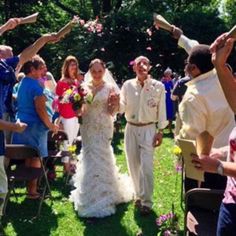 the bride and groom are throwing confetti at each other as they walk down the aisle