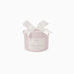 a pink candle with a white bow on it's lid and ribbon around the top