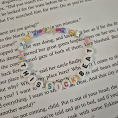 a close up of a book page with a bracelet on it's side and words written in small letters